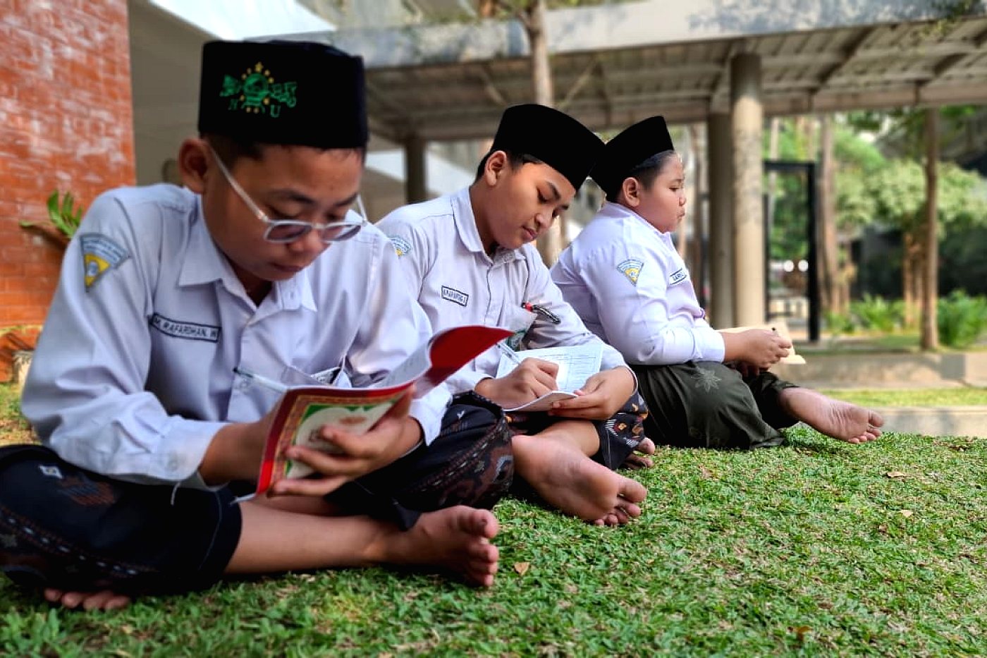 Membaca pelajaran di halaman madrasah
