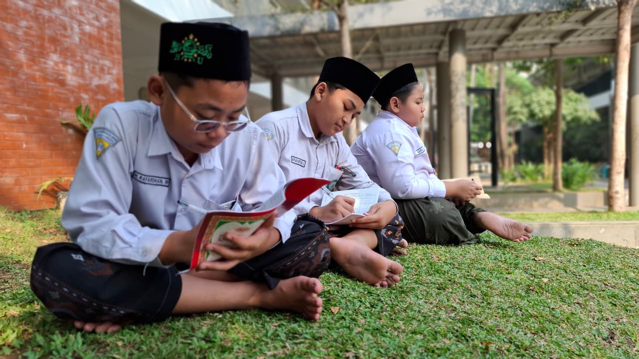 Membaca kitab bersama di atas rumput halaman